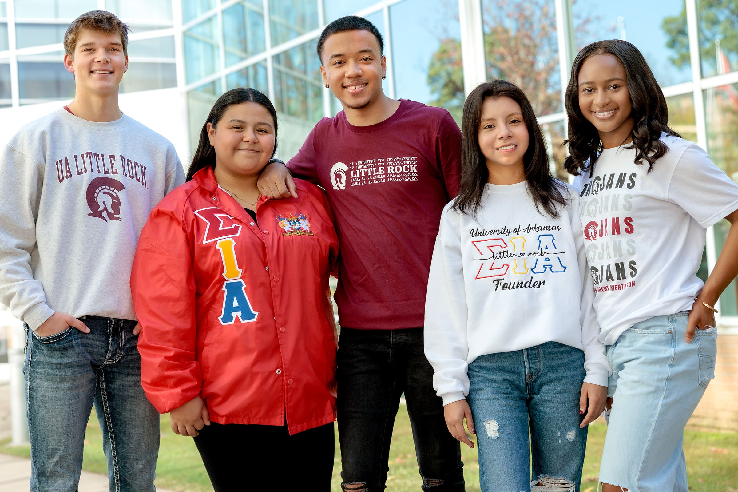 Five students with their arms around each other.