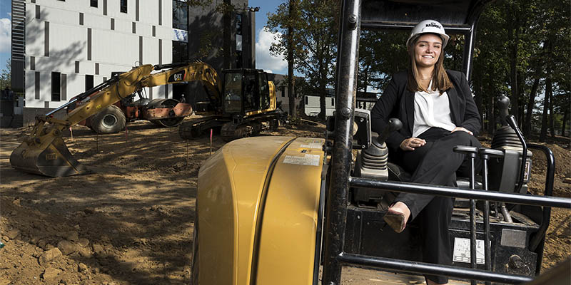 Smiling construction management student on a construction site.