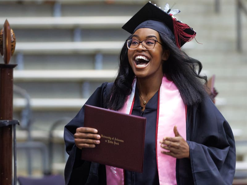 A happy, female graduate after receiving her diploma.