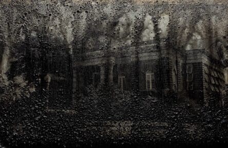 Chris Revelle, Conviction (Talladega 2), bituminous coal and wax on postcard. An image of a plantation home covered with a textured, black substance partially obscuring the image.