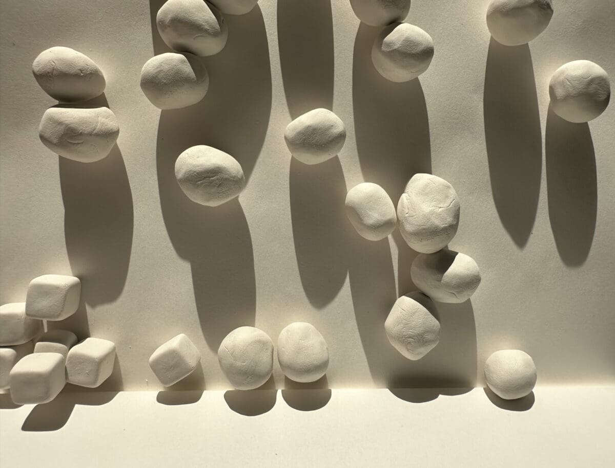 An image of pebble or rock-like clay forms attached to a wall.