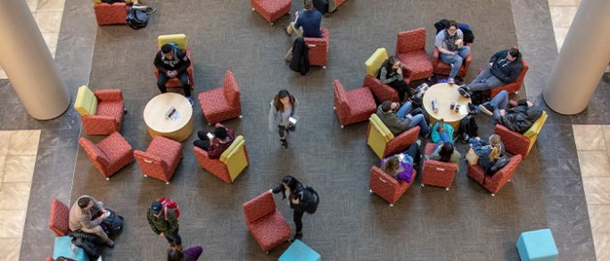Overhead view of business degree students in campus lounge.