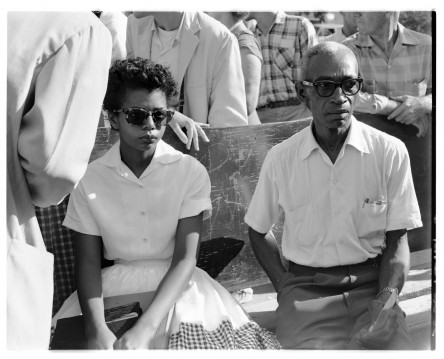 image of Elizabeth Eckford and L.C. Bates sitting on a bench outside of Little Rock Central High School, 1957 (Raymond Preddy Photographs, UALR Center for Arkansas History and Culture)