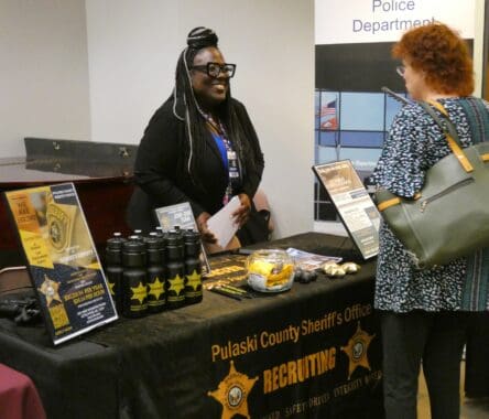 Picture of police recruiter talking to a college student.