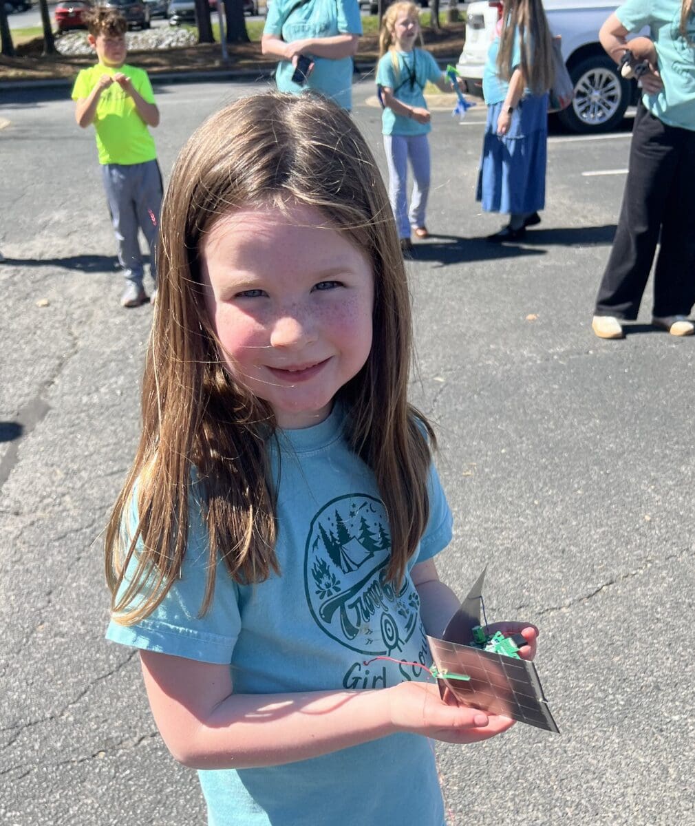 child holding a solar powered electronic