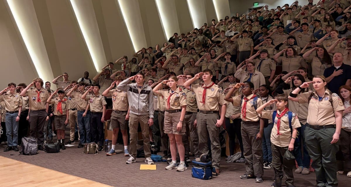 Hundreds of Scouts, leaders, and family members salute during the Merit Badge University opening ceremony at UA Little Rock.