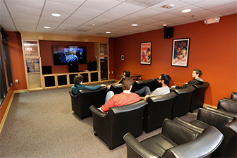 Students watch a movie in a theater in the Commons Apartments.