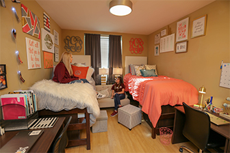 Two students hang out inside a dorm room in West Residence Hall.