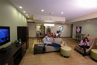Six students hang out in a kitchen and recreation area inside West Residence Hall.