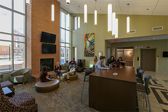 A group of students hang out in the lobby of West Residence Hall.