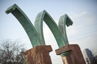 Photo of 'flying letter W' which is a sculpture mounted on two stone columns in front of the Bowen Law School