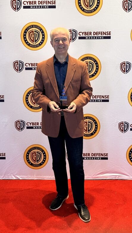 Photo of Dr. Veysel Erdag standing and holding his CISO Top Global Award.