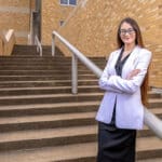 Sarah Davis stands on the back steps of the UA Little Rock William H. Bowen School of Law.