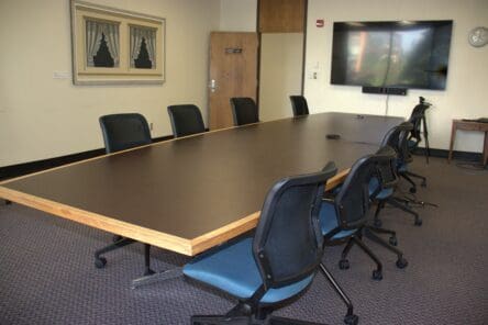 201C an image of a room with a table and chairs and monitor.