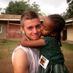 A young child gives James Sellers a kiss on the cheek during his missions trip