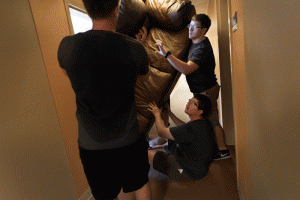 Volunteers work together to fit a sofa through the door during UALR's move-in day on Wednesday, Aug. 12.