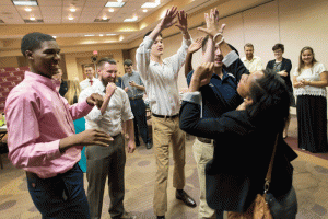 Resident assistants celebrate after a team-building exercise during student housing training.