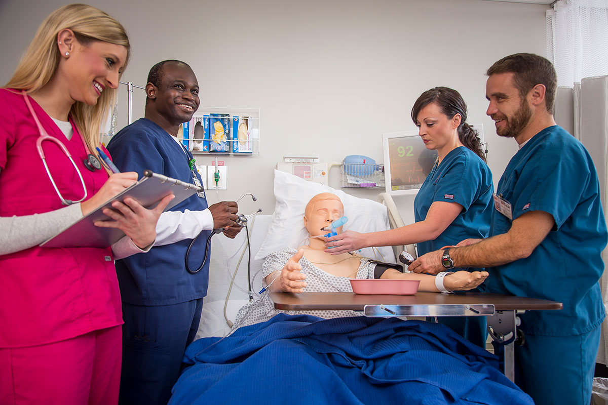 Nursing students with a patient care mannequin