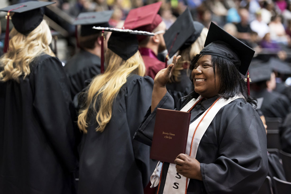 A graduate waves during the Fall 2015 commencement ceremony.