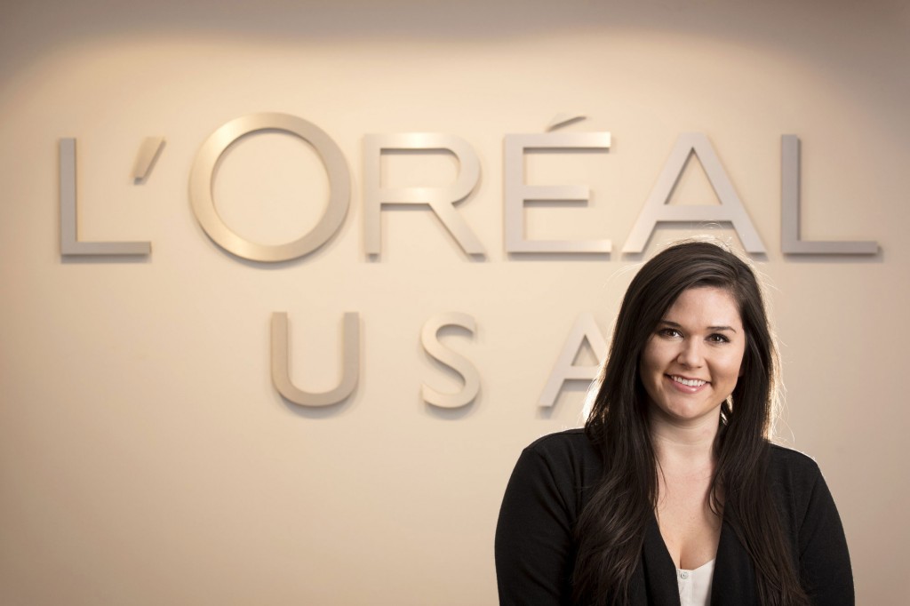 Christa Rowland stands in front of a L'Oreal USA sign