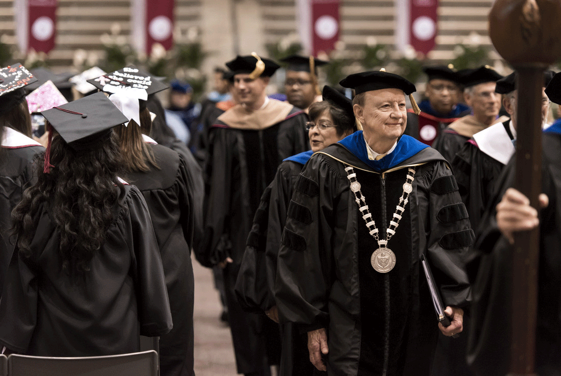 Chancellor Joel E. Anderson walks to the stage during the 2016 spring commencement at Jack Stephens Center.