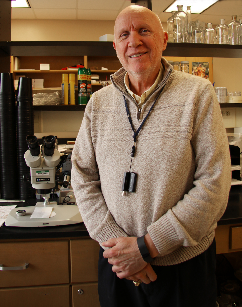 Dr. Carl Stapleton stands in front of the lab equipment used to test mosquitos.