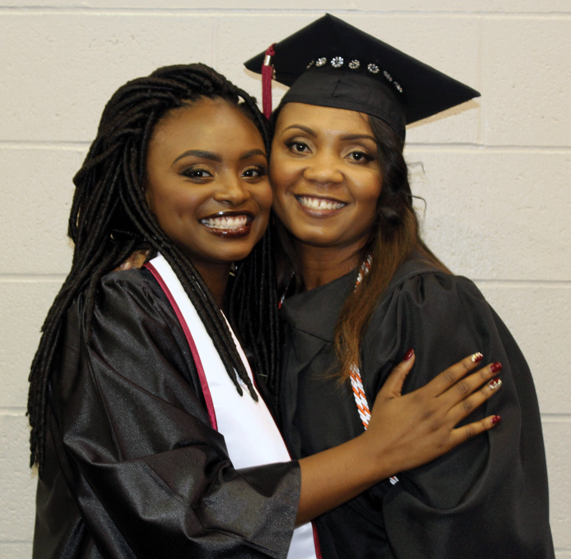 Arial King (left) hugs her mother, Pamala Stanley (right), during their graduation from the University of Arkansas at Little Rock May 14 at Jack Stephens Center.
