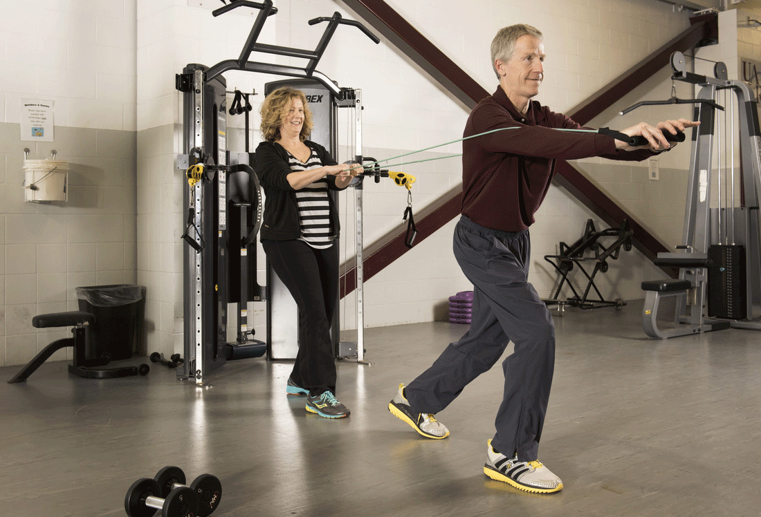 Marie Sandusky (left), UALR director of health services, works out with Karl Lenser (right), UALR employee wellness coordinator. Photo by Lonnie Timmons III/UALR Communications.