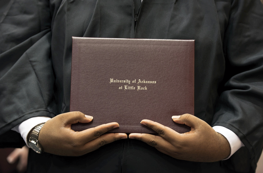 A University of Arkansas at Little Rock graduate holds his diploma during commencement.