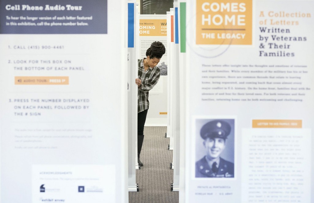 Library student worker JoBeth Phifer arranges a new exhibit featuring war letters at Ottenheimer Library. Photo by Lonnie Timmons III/UA Little Rock Communications. 