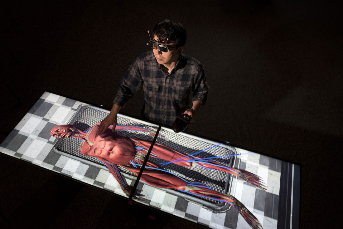 Emerging Analytics Center Student Researcher Ramiro Serrano Vergel dissects a virtual corpse on the Immersive virtual reality table at the EAC center. Photo by Lonnie Timmons III/UA Little Rock Communications.