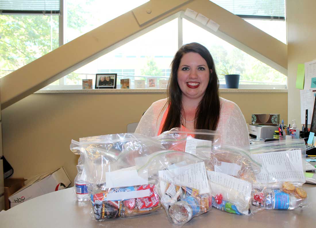 Ashley Henry-Saorrono is surrounded by car care kits for the homeless she created with the Saline County Progressives.