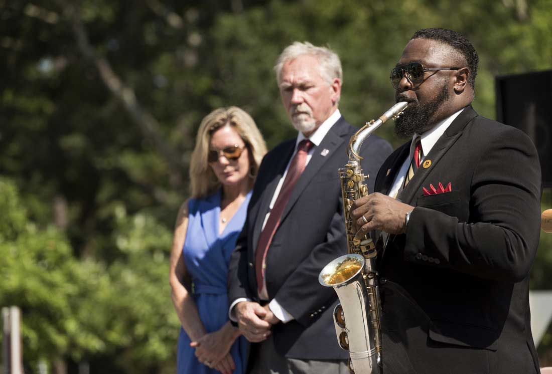 Janessa Rogerson and Chancellor Andrew Rogerson watch Michael Eubanks plays the taps during UA Little Rock's May 30 Memorial Day service. Photo by Lonnie Timmons III/UA Little Rock Communications.