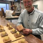 Michael Warrick individually numbers the wooden "spirit houses" for CRE8.