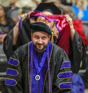 UA Little Rock criminal justice doctoral student Marc Glidden, a visiting assistant professor of criminal justice, is hooded during the May 11 graduation ceremony. Photo by Ben Krain. 