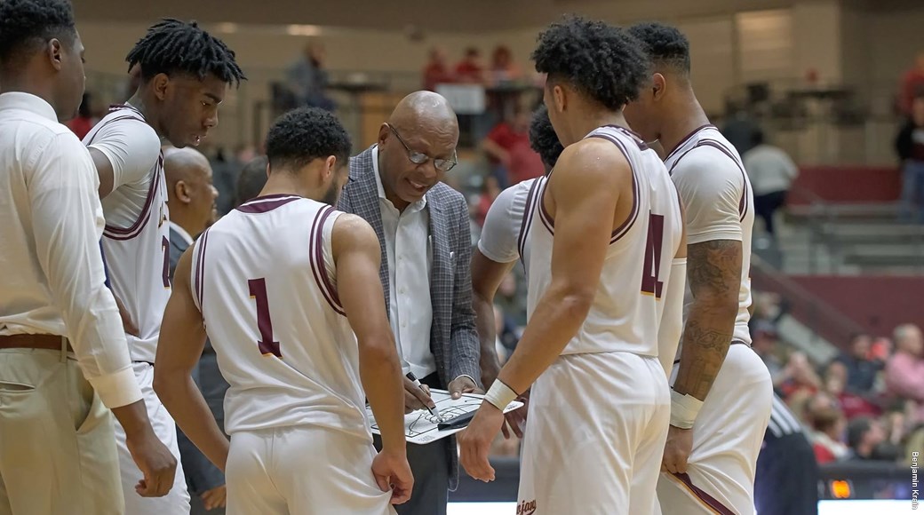 Coach Darrell Walker strategizes with members of the men's basketball team.