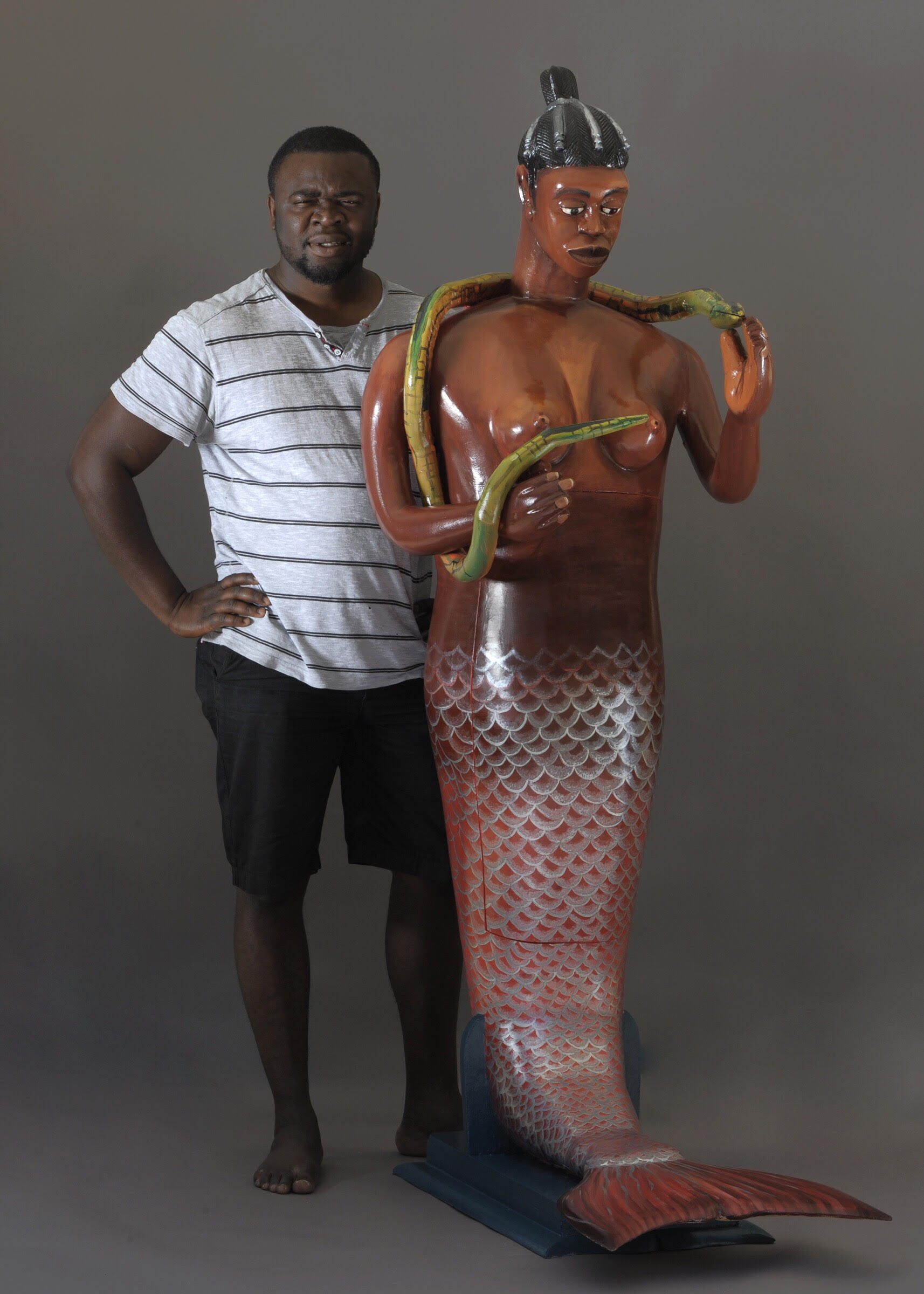 Eric Adjetey Anang stands in front of one of his coffins that will be featured in the exhibit "Celebrating Death: Fantasy Coffins of Ghana."