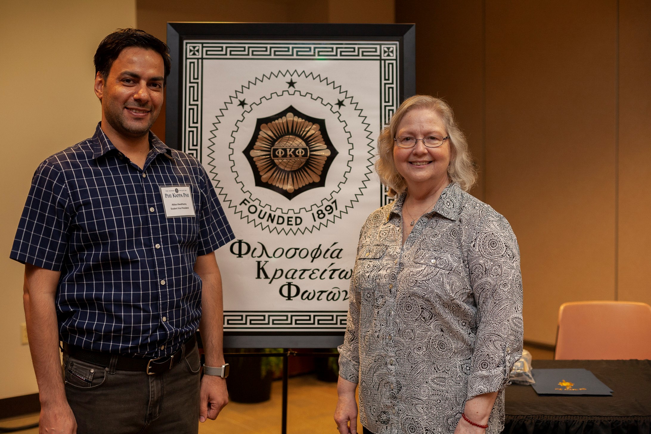 Phi Kappa Alpha Administrative Liaison-Linda Stipsky talks with Phi Kappa Alpha Vice President Abbas Al-Wahhamy during the 2019 induction ceremony.