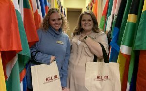 Study Abroad staff members Leslie Parker, left, and Emily Bell, right, receive tote bags after donating to the Campus Campaign. 