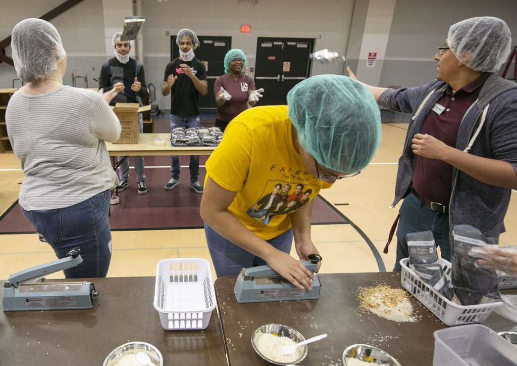 UA Little Rock students, faculty, and staff fill ready-to-cook meal bags during a Feed-the-Funnel philanthropy event facilitated by The Pack Shack hunger relief charity. Participants made 10,000 meals which will be donated to the Trojan Food Pantry. Photo by Ben Krain.