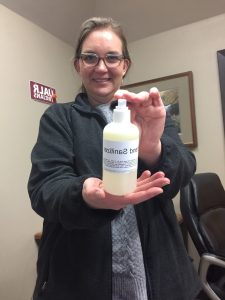 Leslie Hutchins holds a bottle of the hand sanitizer made by Facilities Management staff. 