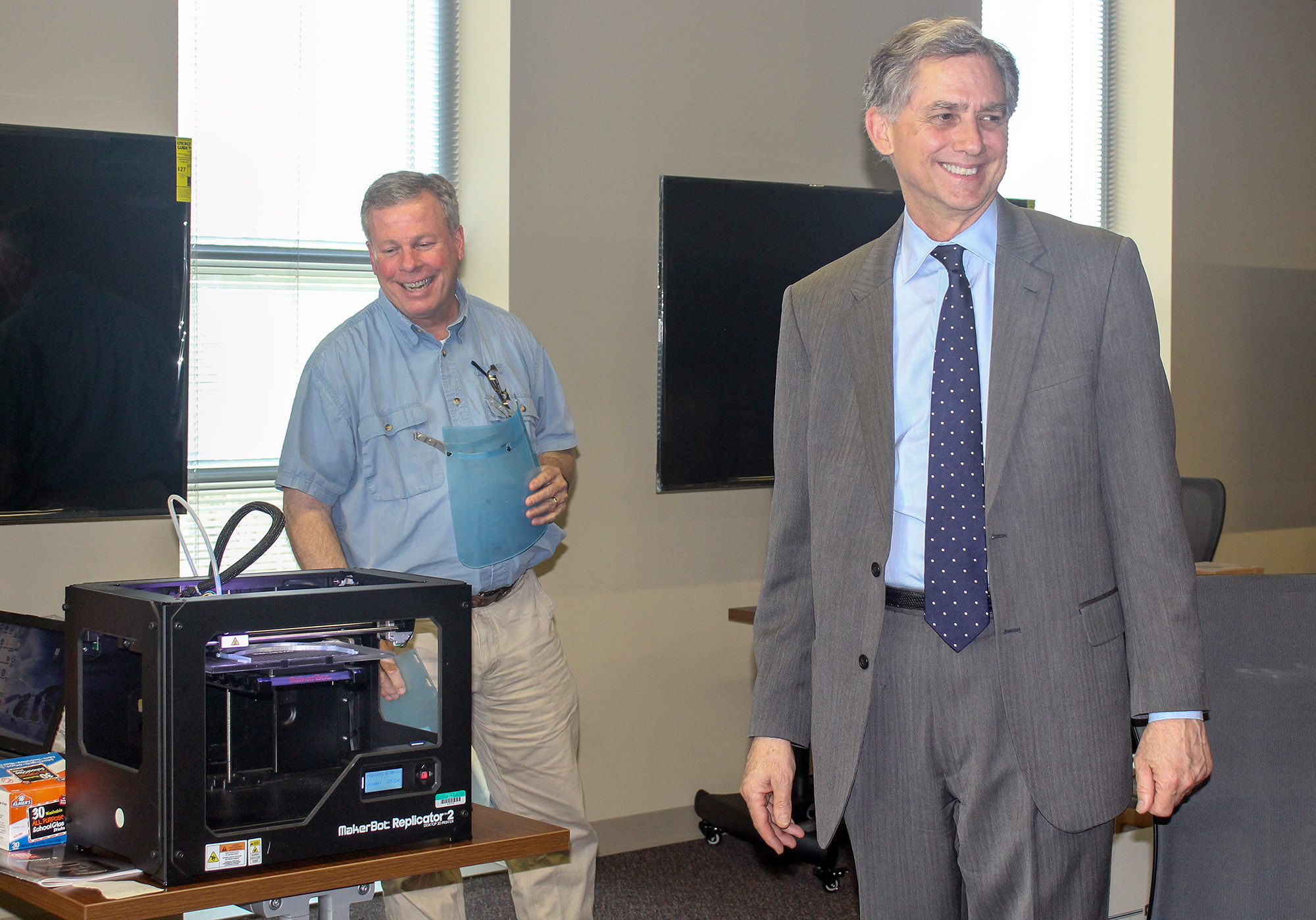 Jay Chesshir (left), president and CEO of the Little Rock Regional Chamber of Commerce, and U.S. Rep. French Hill (right) inspect the 3D printers that are printing face shields for CHI St. Vincent. Photo by Angie Faller.