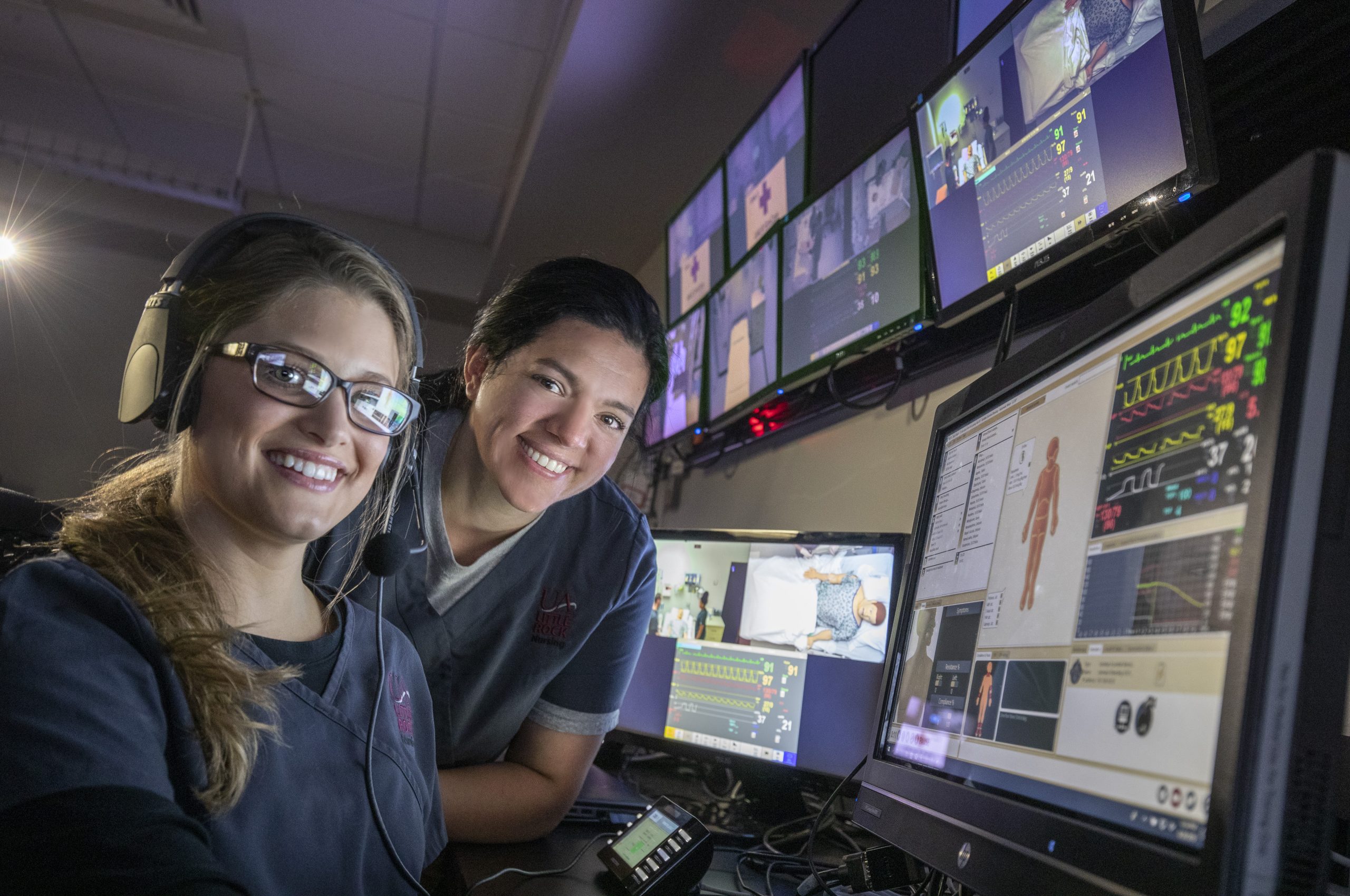 Nursing school students work with medical equipment in the SIM Lab control room. Photo by Ben Krain.