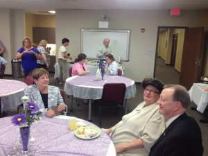 Linda Pine, middle, speaks with Deborah Baldwin, left, and Joel Anderson, right, during her retirement party at Ottenheimer Library.