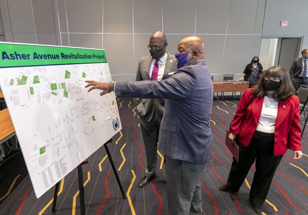 UA Little Rock Chancellor Christina Drale (right), Mayor Frank Scott Jr. (left), and business owner Tracy Johnson (center) review plans for revitalization efforts along Asher Avenue during a Sept. 2 press conference at Robinson Hall. Photo by Ben Krain.