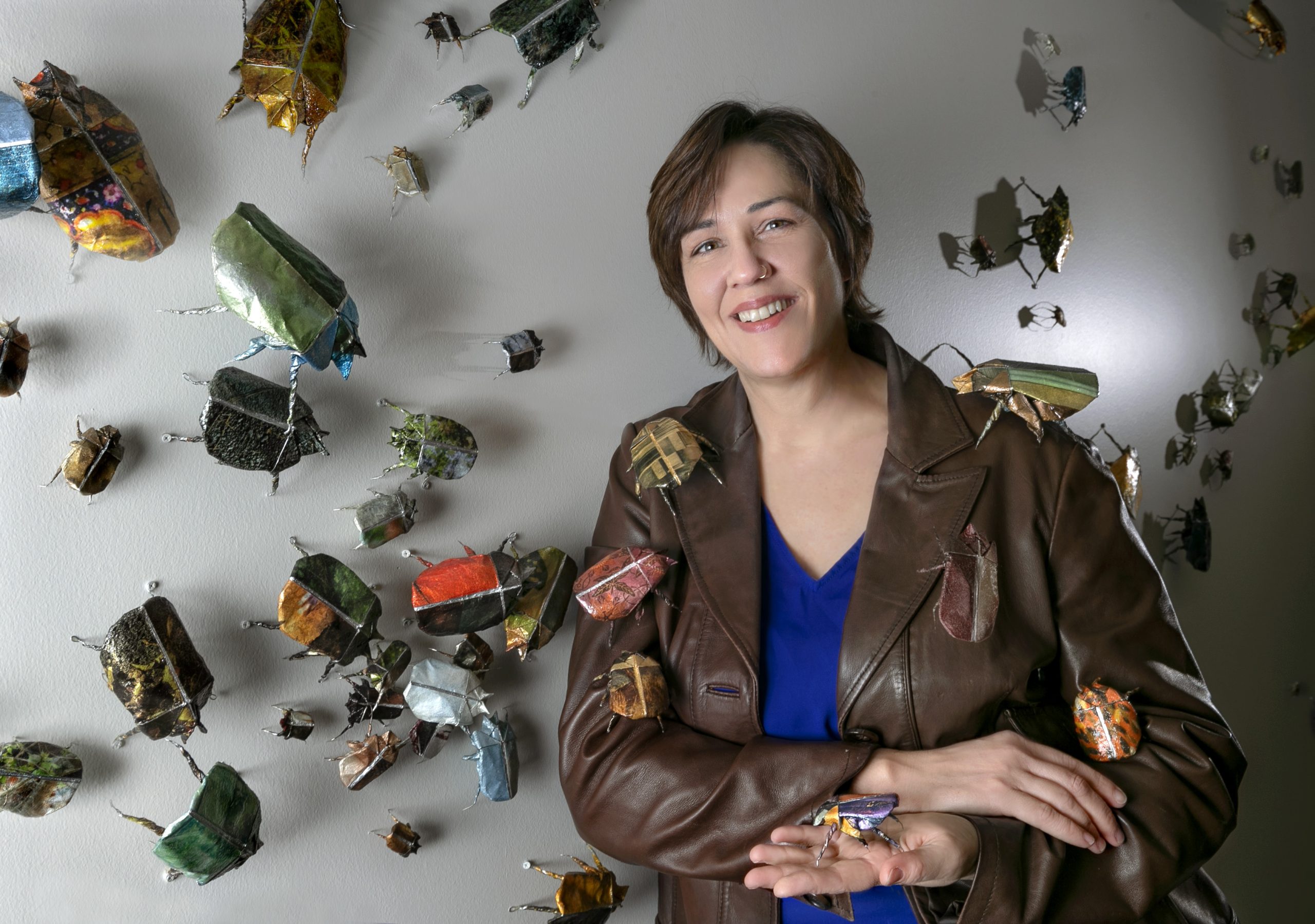 Joli Livaudais with her installation of paper beetles on display in the Windgate Center.