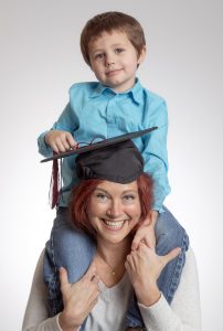 UA Little Rock first-generation student and single mom Erin Clement tries on her graduation cap with her son Ehren. Photo by Ben Krain.