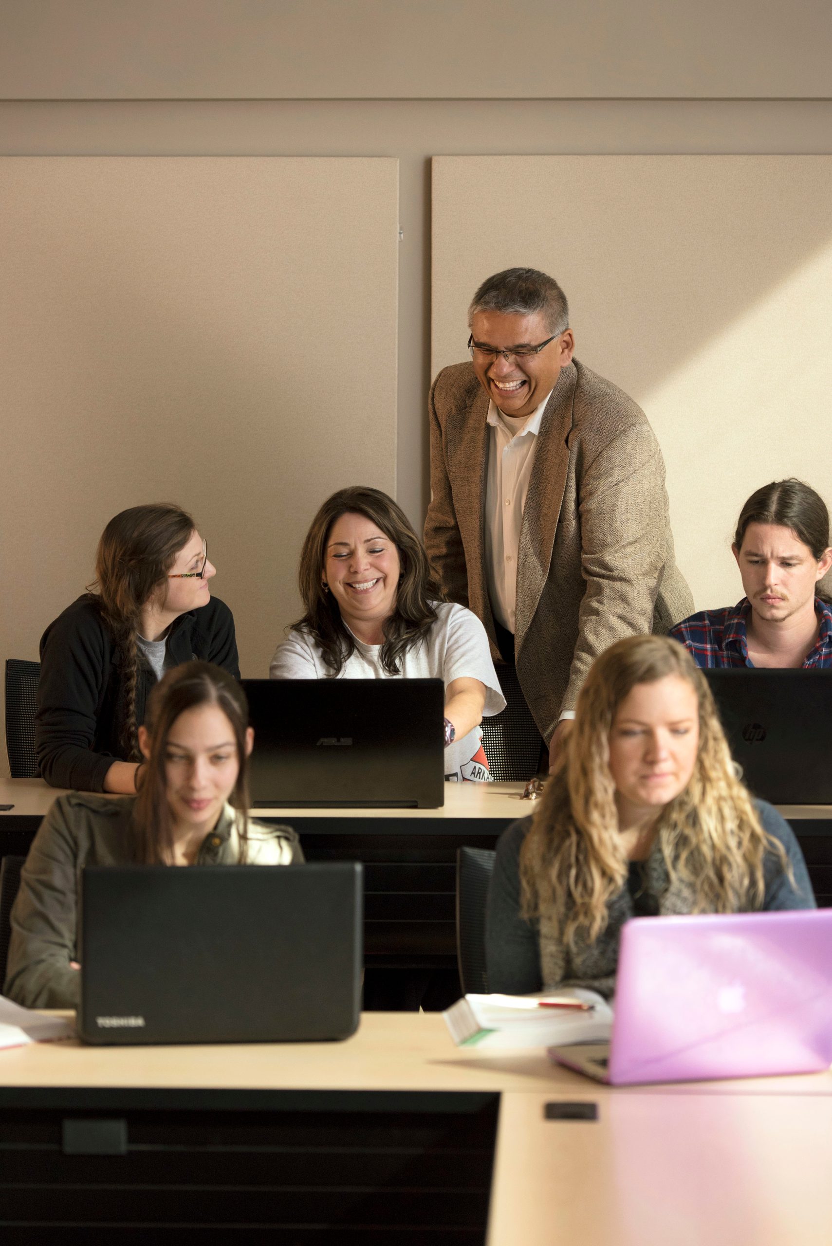 Business instructor interacts with students in the classroom.