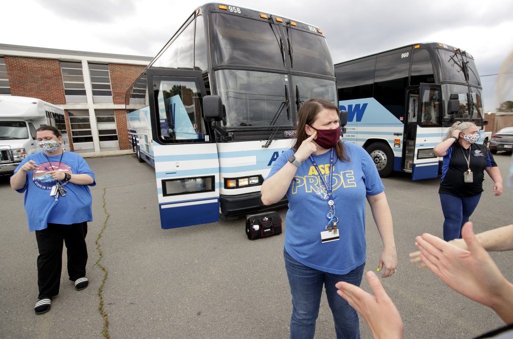 Jennifer Blanks, center, communicates in sign language to other staff members at the Arkansas School for the Deaf about boarding students onto buses before the school’s weekend dismissal. Photo by Ben Krain.