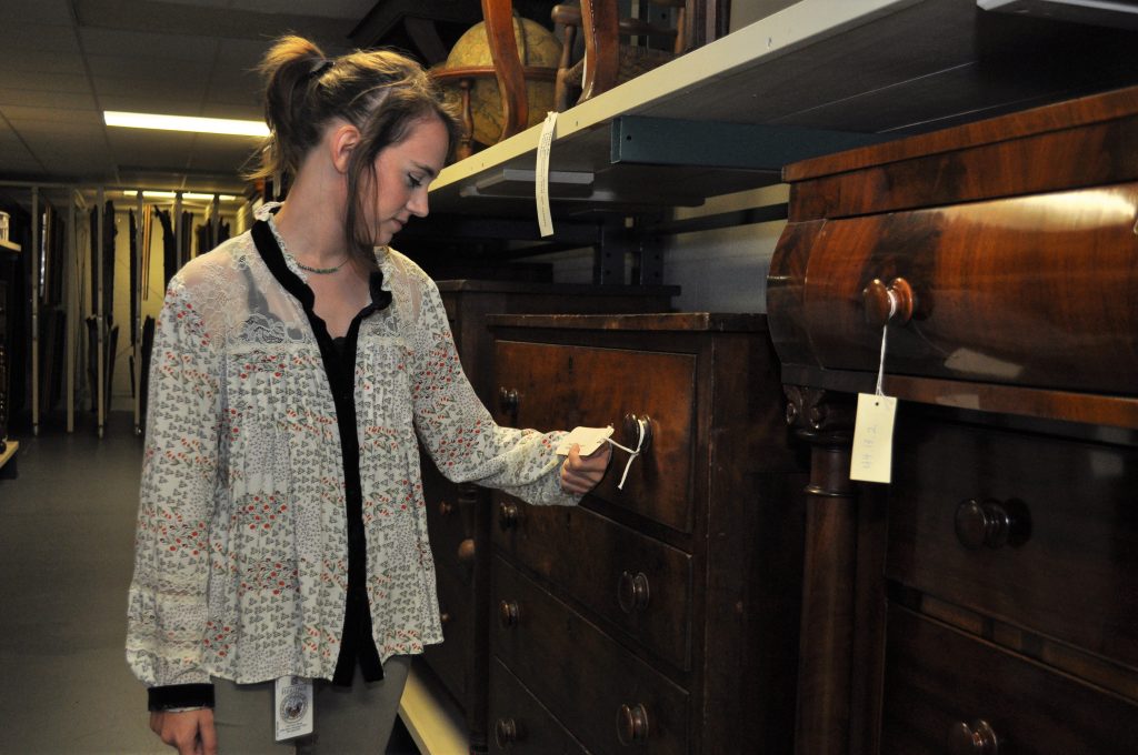 Jordan Hancock examines items in Historic Arkansas Museum's collection. 